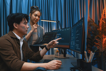 Serious of IT developers discussing intelligent website development coder system running data online two screens with laptop showing information network at neon light room at modern office. Infobahn.