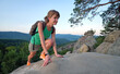 © bilanol - Sportive woman climbing alone on hillside rocky trail. Female hiker overcoming difficult cliff on wilderness path. Active lifestyle concept