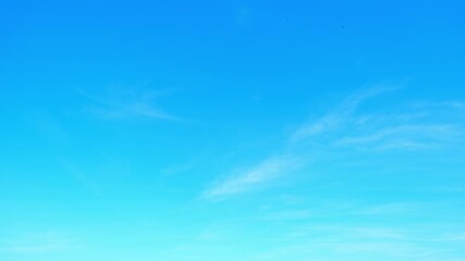 Wall Mural - A timelapse of a vibrant blue sky with delicate wisps of clouds drifting across the frame, reflecting a clean environment and stable conditions, symbolizing clarity, openness, and natural tranquility.