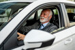 © Zamrznuti tonovi - Senior businessman driving modern car smiling and looking away