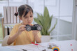 © FAMILY STOCK - Asian girl inspecting robot car she built, learning STEM education and robotics engineering. Concept of child creativity, electronics, innovation, future technology skills and digital learning.