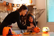 © itchaznong - Creative Halloween Pumpkin Carving with Mother and Daughter