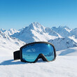 © joe - Pair of black ski goggles resting on snow-covered mountain slope reflecting alpine landscape. Winter sports equipment for a skier or snowboarder in a snowy mountain resort.
