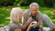© Prostock-studio - Two seniors share a delightful moment in a green garden, smiling and savoring dessert together. Surrounded by plants, they are clearly enjoying the warm weather and each other's company.