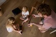 © Westend61 - Father teaching son and daughter while playing together indoors