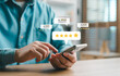 © Looker_Studio - Close-up of a person using a smartphone to leave a five-star review with digital rating icons, concept of customer satisfaction, feedback, online reputation and user experience.