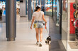 © ADDICTIVE STOCK - Woman with dog walking through indoor shopping mall