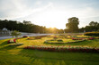 © Travel 'n' Lifestyle - View of golden sunlight bathes the manicured lawns and vibrant flowerbeds in a formal garden, casting long shadows across the landscape, SchÃ¶nbrunn, Wien, Austria.