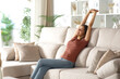 © PheelingsMedia - Happy woman stretching and raising arms at home