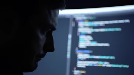 Focused Programmer Working Late Night on Computer Code in Dark Room.