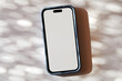 © Tetra Images - Blank smart phone on abstract background