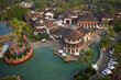 © AmazingAerialAgency - Bambolim, India - 16 November 2013: Aerial view of a luxurious resort complex with intricate tiled roofs, turquoise pools, and verdant palm trees contrasting against the light sandy pathways.