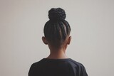 Back view of a child with an elaborate braided hairstyle, highlighting the artistry and cultural significance of hair braiding