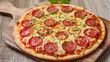 © AliRza - A classic pepperoni pizza sits on a rustic wooden cutting board. The round pizza is topped with melted cheese and slices of pepperoni, with fresh parsley sprinkled on top.