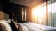 © Evi - Hotel bed with crisp white linens and decorative pillow in soft morning light through sheer curtains.