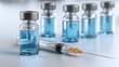 © Studio Zenith - Seringue medicale et flacons de vaccin bleus sur surface blanche