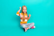 © deagreez - Cheerful young girl in trendy clothes posing on vibrant turquoise background with an enthusiastic expression