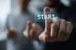 © Bagas - Large 'Start' buttons pressed simultaneously Close-up of different hands pressing the large glowing START button, symbolizing the beginning of a new business