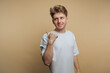 © bodnarphoto - Smiling young man gestures with his thumb in a casual atmosphere during indoor shoot