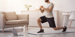 © Prostock-studio - Athlete trains at home, new normal and online lesson during covid-19. Cheerful arabian bearded young guy doing lunges, for legs in living room interior, looks at laptop on floor, near bottle of water