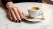 © Store - Elegant Woman's Hand Resting Beside a Freshly Brewed Espresso Cup on Marble Table
