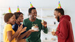 © Prostock-studio - Happy black friends making surprise for excited birthday guy, holding birthday cake and smiling. Cheerful african american group celebrating birthday together, wearing party hats, drinking champagne