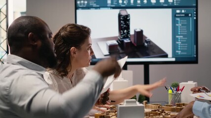 Diverse engineers team go over structural real estate city planning using 3D models to visualize residential layout expansion and infrastructure growth on the table. Innovation hub. Camera B.