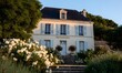  a symmetrical, pretty, classically french house in the loire region with window box flowers and pale blue shutters