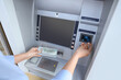 © Pixel-Shot - Businesswoman with credit card withdrawing dollar banknotes from ATM outdoors, closeup