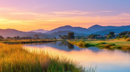 Wall Mural - Serene sunset over a tranquil river with lush greenery and distant mountains reflecting in the water
