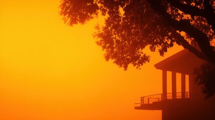 Wall Mural - Serene sunset view over a lake with silhouetted trees and a house, creating a tranquil atmosphere