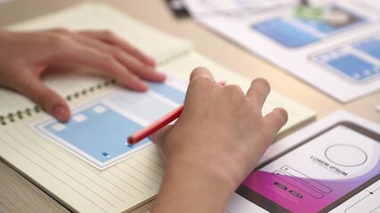 Startup company employee planning for user interface prototype for mobile application or website in office with model of program on desk. UX UI designer consider user friendly interface plan. Synergic