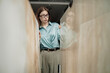 © Seventyfour - Caucasian young adult woman wearing glasses examining large marble slabs in showroom, standing between stone panels, focused expression, hands touching surfaces, indoor setting