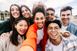 © Xavier Lorenzo - Young group of diverse student friends taking selfie portrait with phone outside. Youth community and international friendship concept