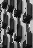 Black and white photo of a modern residential building facade with repeating dark balconies creating