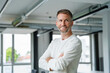 © Westend61 - Confident businessman posing in modern office setting looking away
