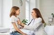 © Studio Romantic - Female friendly doctor with stethoscope examining child's lungs, breathing and heart rate sitting on the couch at the hospital. Pediatrician woman checking a little patient boy in exam room.