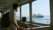 © Big - A man and a child look out from a ferry window at another ship on the water.