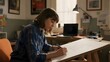 © Big - A person is drawing on a large sheet of paper at a desk in a well-lit room.