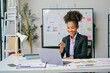 © Parichat - Happy african american businesswoman attending a video conference in modern office