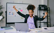 © Parichat - Excited african american businesswoman celebrating success in modern office