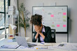 © Parichat - Stressed african american businesswoman covering face with hands at office desk