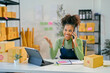 © Parichat - Smiling african american woman managing her small business talking on phone
