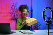 © Parichat - Influencer showing package while recording video for social media using ring lamp