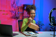 © Parichat - Excited african american woman unboxing package while recording video blog