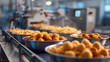 © sornram - Freshly cooked golden snacks are ready for packaging in a food production facility, showcasing quality and efficiency.