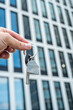 © RomanR - Keys in Hand Against Modern Office Skyscrapers – Real Estate and Investment Concept.  Perfect for business  real estate finance and architecture-related visuals.