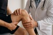 © Татьяна Евдокимова - Doctor palpating athlete's knee, checking for joint mobility and pain, providing healthcare and diagnosis
