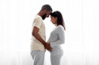 © Prostock-studio - Cheerful young black man and pregnant wife enjoy tender moment in bedroom interior on window background, profile. Happy family, future parenting, expecting of child, relationship at home, free space