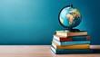 © Janet - stack of books on table and globe against blue wall international day of education concept copy space world book day